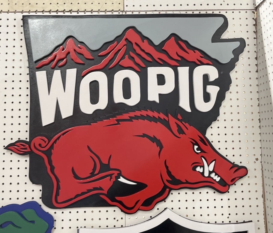 Arkansas-shaped 'Woo Pig' sign with hand-cut mountains behind the hog