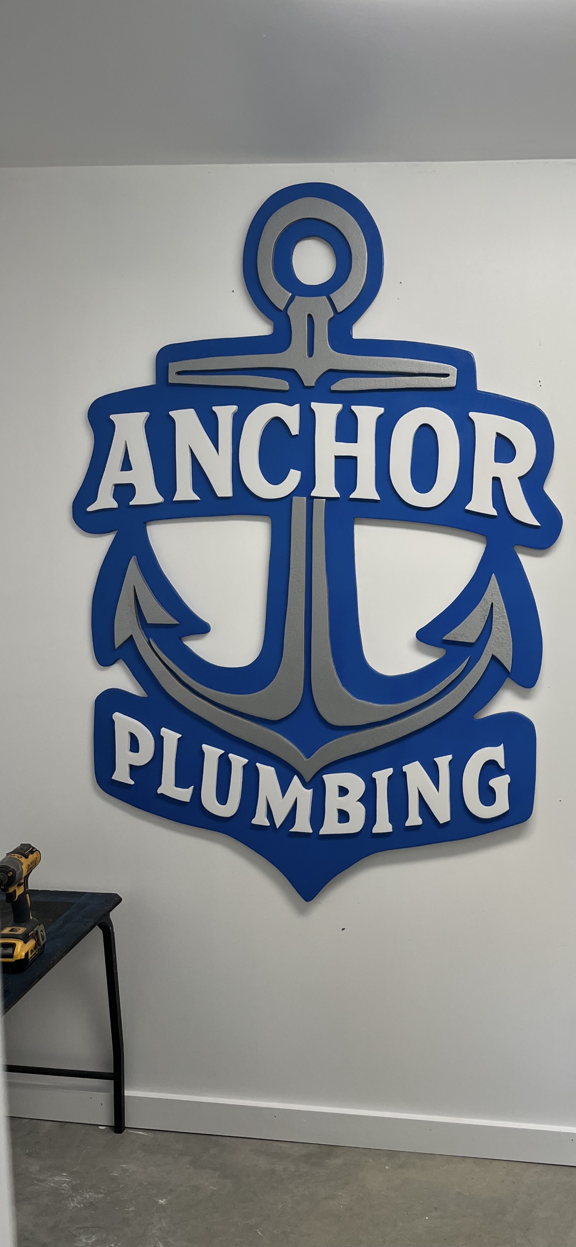 'Anchor Plumbing' anchor logo sign, cut in layers and mounted on the shop wall