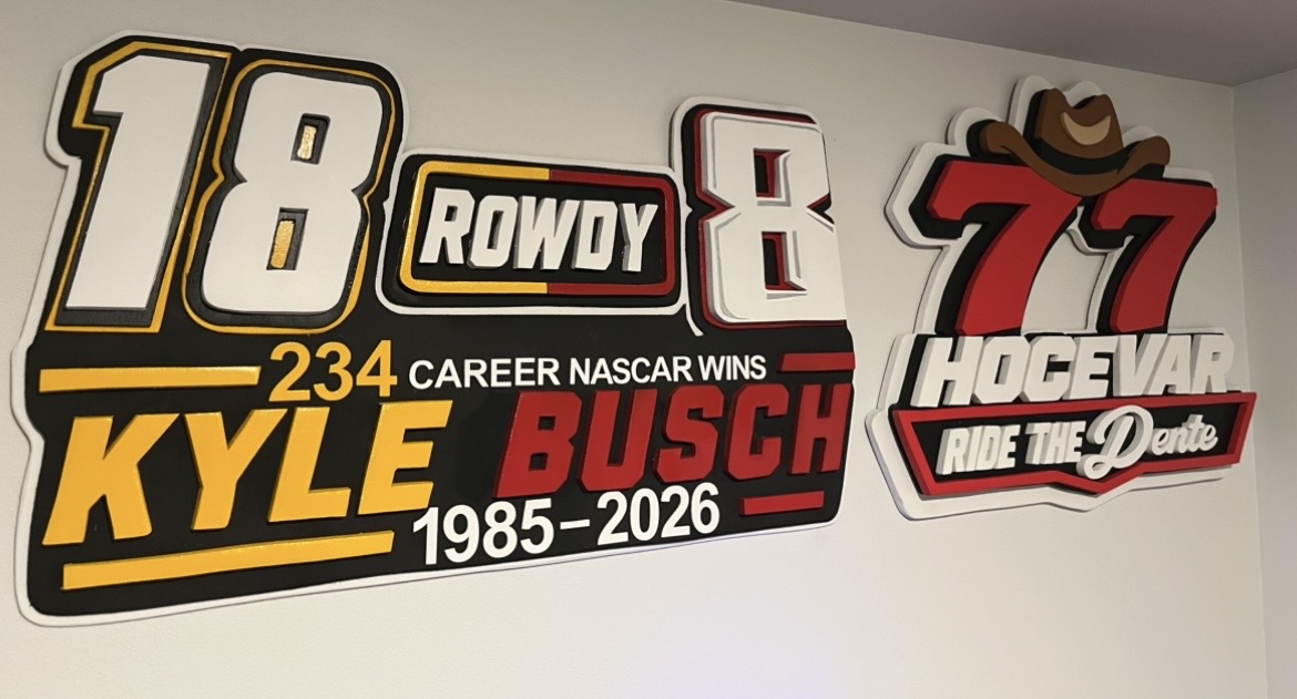 Kyle Busch 'Rowdy' 234-career-wins tribute and a Carson Hocevar #77 'Ride the Dente' sign, both hand-cut and layered
