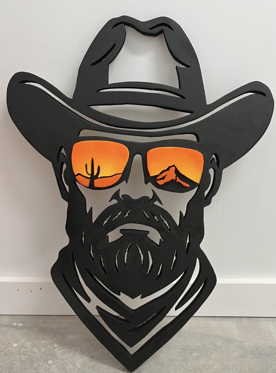Bearded cowboy in a bandana with a desert sunrise cut into the sunglasses