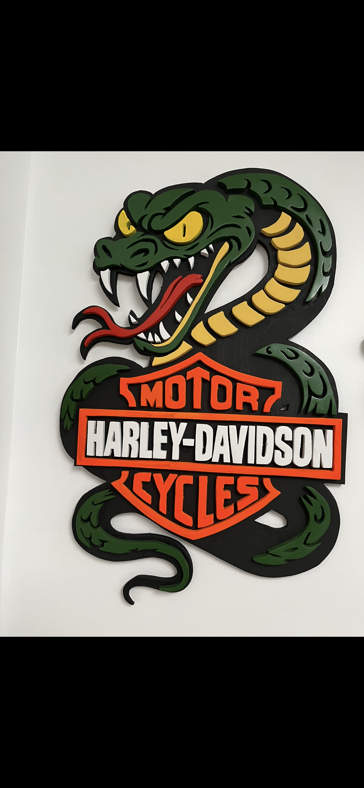 Bar and shield wrapped in a hand-cut striking cobra, painted in deep green and orange