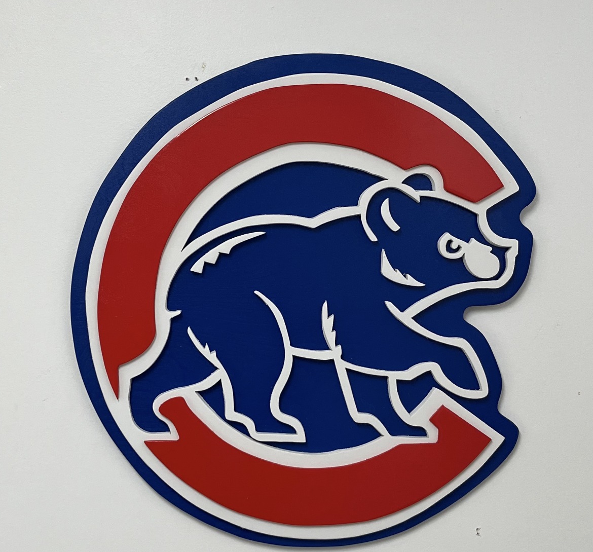 Chicago Cubs logo sign, the outer ring, inner circle and the C all cut as separate pieces and layered, then hand-painted in Cubbie blue and red, example of custom handmade wood work