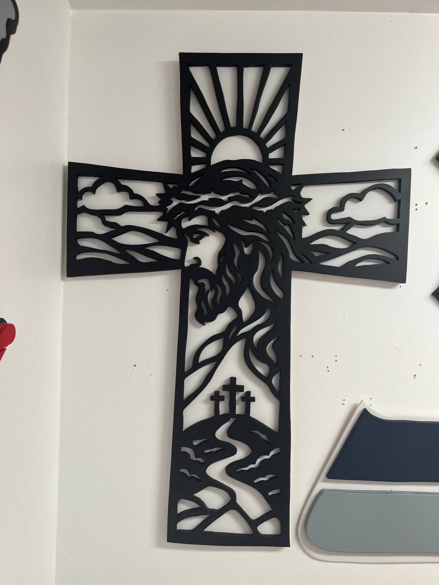 Sunrise fretwork cross with clouds, three hills and a winding path